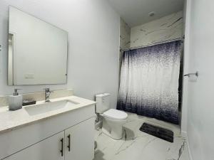 a bathroom with a sink and a toilet and a shower at Honeycomb Haven in Davenport +17 photos
