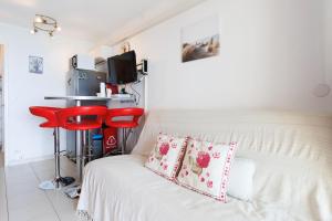 カンヌにあるSuite 322 - Sea View - Beach - Clim - Wifiの部屋にある白いベッドと赤いスツール