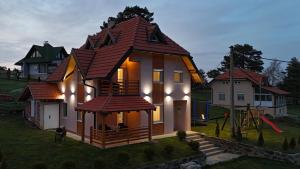 una piccola casa con un tetto in cima a un cortile di Apartmani Radovanović a Divčibare