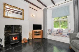 a living room with a fireplace and a tv at Fairfield Cottage in Boscastle