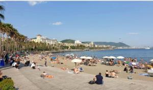 a group of people sitting on a beach at Salerno Mare e Luci in Salerno