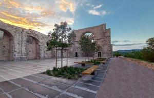 a building with benches and trees in front of it at Castua Residence in Kastav
