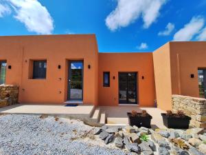 an orange building with some plants in front of it at Terracotta Sunset Naxos in Galanádhon