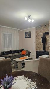 un soggiorno con un divano e un tavolo di Apartmani Radovanović a Divčibare