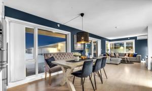 a dining room with blue walls and a table and chairs at Large apartment with 4 bedrooms, free Parking, 400m from trainstaion in Lillestrøm