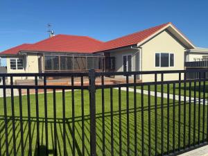 una recinzione di fronte a una casa di Sun filled character home a Napier