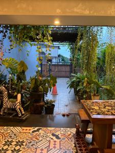a patio with a bunch of plants and a table at Pendopo Nilam Den Erwin in Karanggan-kulon