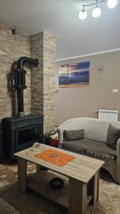 un soggiorno con divano e camino di Apartmani Radovanović a Divčibare Altre 17 foto