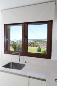 a kitchen with a sink and a window at Soledá e Pepa II in Noya