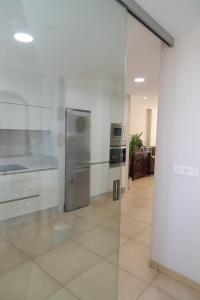 a kitchen with stainless steel appliances and a glass wall at Soledá e Pepa II in Noya +56 photos