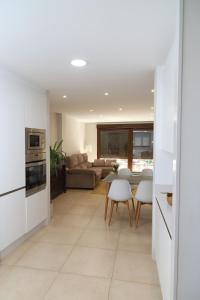 a kitchen and living room with a couch and a table at Soledá e Pepa II in Noya