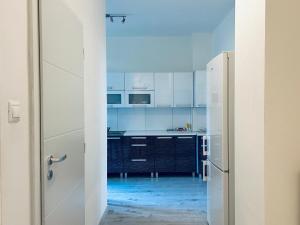 a kitchen with white cabinets and a white refrigerator at Sweet Dreams - cozy Stay in city center in Bratislava +4 photos