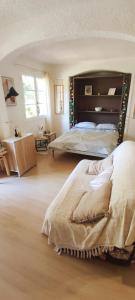 a bedroom with two beds with a large headboard at Charmant studio proche mer avec piscine in Les Issambres