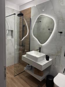 a bathroom with a sink and a shower and a mirror at Rania Residence in Skopelos Town +59 photos