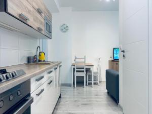 une cuisine avec des placards blancs et une table avec une chaise dans l'établissement Good Vibes Only - spacious Residence, à Bratislava