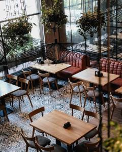 a restaurant with wooden tables and chairs and windows at АРКАДИЯ ОДЕССА Новые апартаменты ЖК Родос Black Sea in Odesa