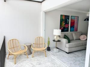 een woonkamer met 2 stoelen en een bank bij Casa Loma next to Xochimilco in Oaxaca City