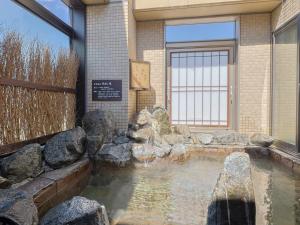 旭川多美迎旭川酒店的一座建筑前的岩石水池