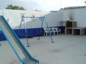 an empty playground with a slide and two chairs at Casa rural el Calvario in Santa María de los Llanos
