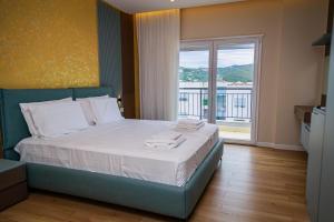 una camera da letto con un letto grande con una grande finestra di Solis Giselle Hotel a Vlorë