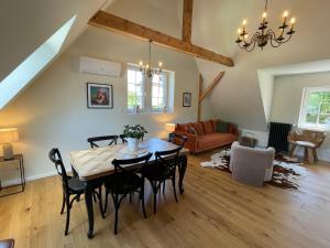 a living room with a table and chairs at Le Hêtre Rouge Charme & Spa Alsace in Barr