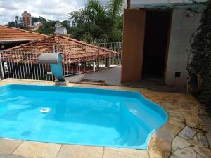 una pequeña piscina azul frente a una casa en Pousada Vicz, en Águas da Prata