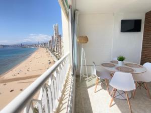 einen Balkon mit einem Tisch und Stühlen sowie Strandblick in der Unterkunft Torre principado 10 in Benidorm