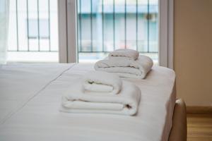 una pila di asciugamani appoggiata sopra un letto di Solis Giselle Hotel a Vlorë Altre 37 foto