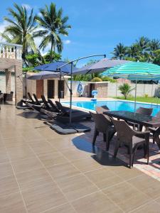 a group of chairs and umbrellas next to a pool at Rancho Plèyades in Metalío