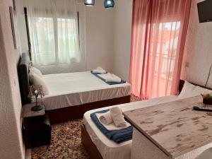 a small room with two beds and a table at PELEKAN rooms and apartments Athina 33 in Pefkohori