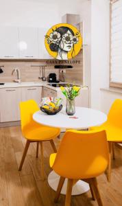 eine Küche mit einem weißen Tisch und gelben Stühlen in der Unterkunft Casa Penelope Lucrino in Pozzuoli