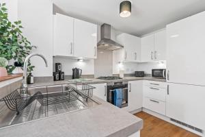 バーミンガムにあるLotus Haus - Wellington Homes - with off road Parkingの白いキャビネットとシンクのあるキッチン