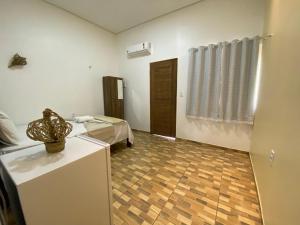 a room with a room with a bed and a table at Vila da Andrea 02 in Barreirinhas +3 photos