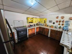 a kitchen with wooden cabinets and a black stove at Rancho Samba do Sol in Acajutla