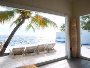 a room with a view of the ocean and a palm tree at Amada Penida Villa in Nusa Penida
