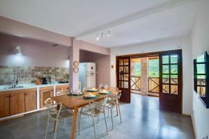 uma cozinha e sala de jantar com mesa e cadeiras de madeira em Casa Brisa do Vale - Lençóis - BA em Lençóis