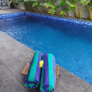 a pair of lounge chairs next to a swimming pool at Cozy 2BR Villa at Kedungu in Tabanan