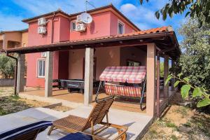 a house with awning and a chair on a patio at Seaside holiday house Jadrija, Sibenik - 24454 in Jadrija
