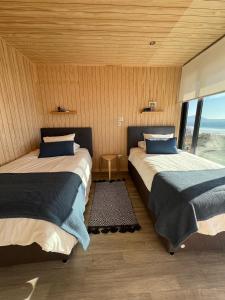 two beds in a room with a view of the ocean at Paraiso junto al mar in Coquimbo