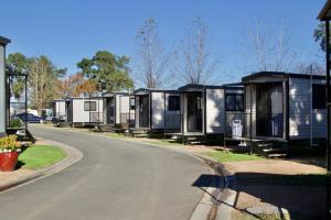 a row of mobile homes on the side of a road at Camden Holiday Park in Camden