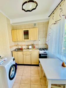 a kitchen with a washing machine and a table at 2-К институт сердця возле Метро Чернігівська in Kyiv