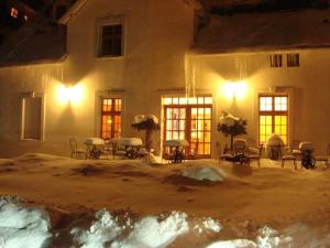 a building with tables and chairs in the snow at night at Willa Viktoria in Inowrocław