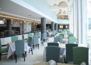 a dining room with tables and chairs and a bar at Résidence Blue Bay Monastir Sousse in Monastir