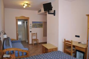 a living room with a bed and a couch and a table at Hotel Vittoria in Riva del Garda