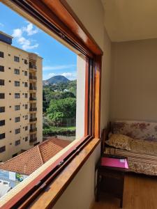 una finestra in una camera con letto e vista di Apartamento amplo 2 quartos no centro ad Águas de Lindóia