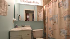 Un baño con lavabo, inodoro y espejo. en Capers Unit 803, en Cape May 13 fotos más