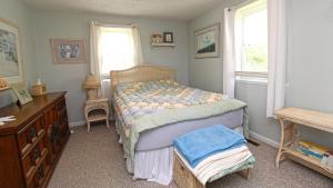 una camera con letto, cassettiera e finestre di Dottys Cottage a Cape May