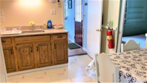 a bathroom with a sink and a kitchen with a table at Little Sandpiper in Cape May Point +15 photos