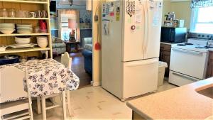 a kitchen with a white refrigerator and a table at Little Sandpiper in Cape May Point