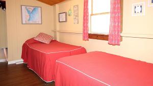 a room with two red beds and a window at Little Sandpiper in Cape May Point